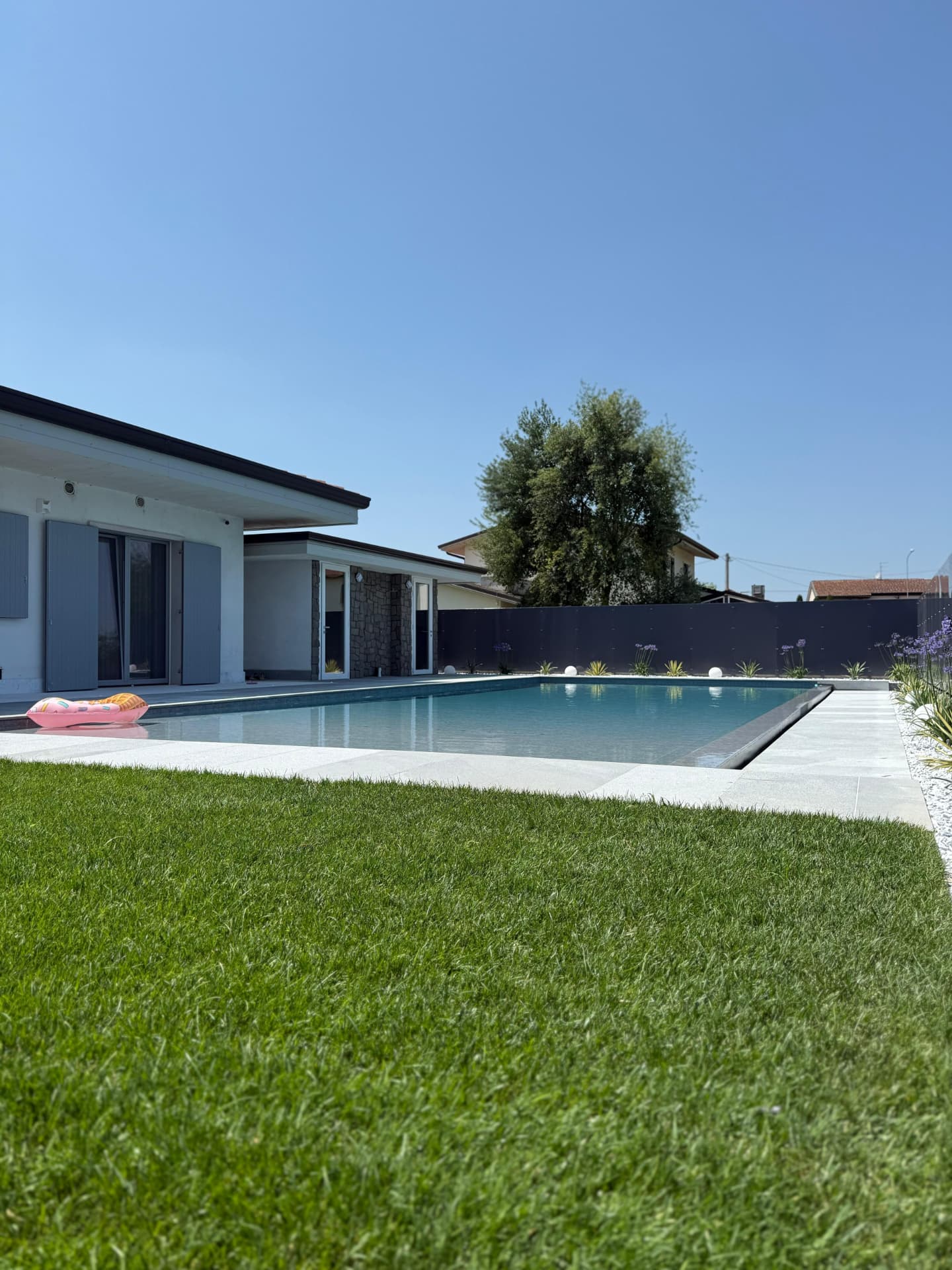 Piscina con prato e vista sulla villa